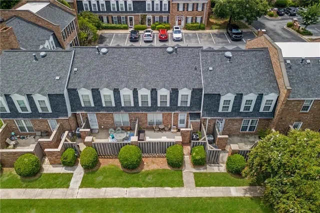 a view of pool with lawn chairs and plants