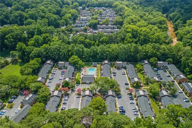 an aerial view of residential house with outdoor space and trees all around