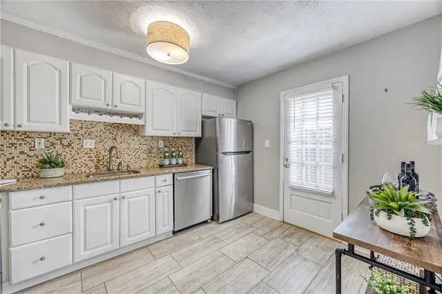 a kitchen with white cabinets and window