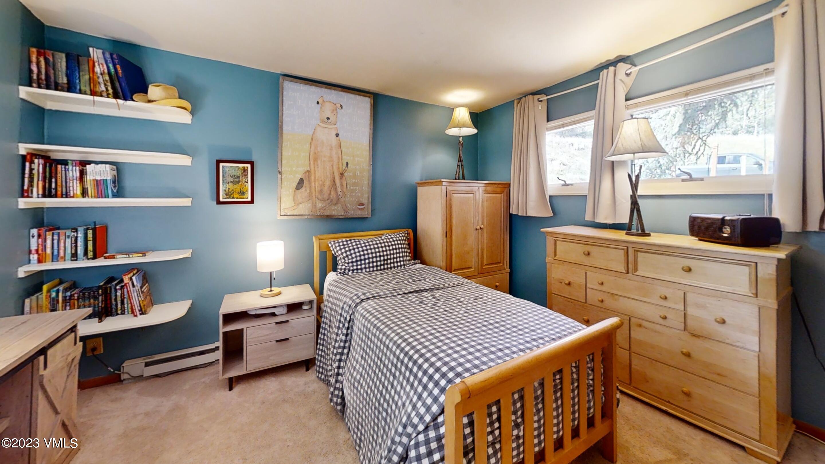 945 Red Sandstone Road, Unit B3 Vail, CO 81657 - Photo 27 of 48 a bedroom with a bed a dresser and a large window