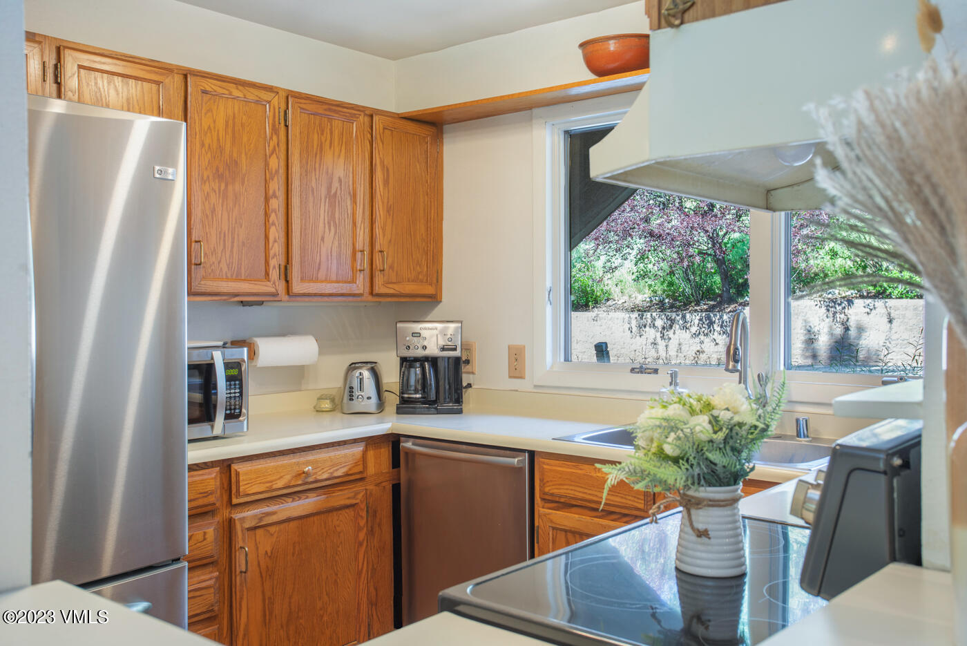 945 Red Sandstone Road, Unit B3 Vail, CO 81657 - Photo 9 of 48 a kitchen with stainless steel appliances granite countertop a refrigerator sink and wooden cabinets