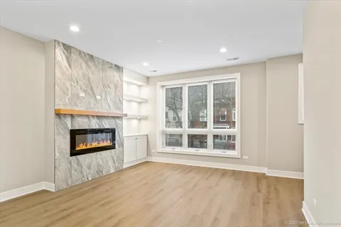 a view of an empty room with a window and fireplace