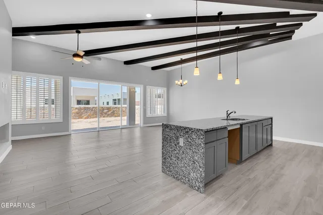 a kitchen with stainless steel appliances granite countertop a kitchen island a stove a sink and a microwave