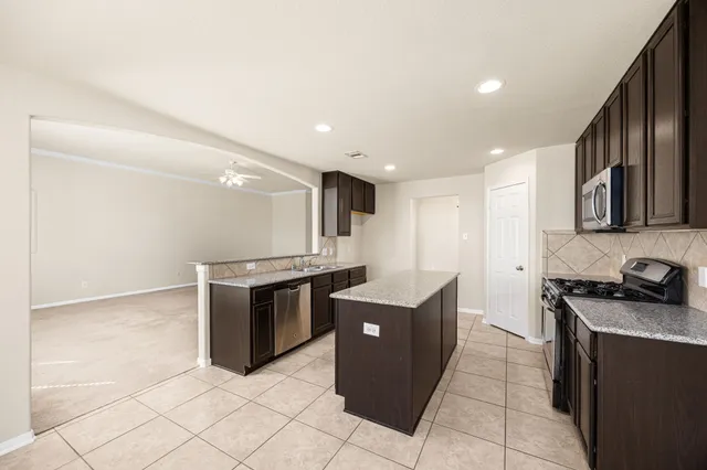 a kitchen with stainless steel appliances granite countertop a stove and a sink
