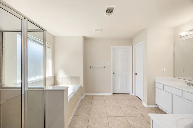 a bathroom with a tub shower and sink