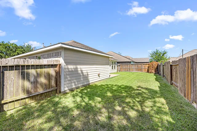 a view of backyard with wooden fence
