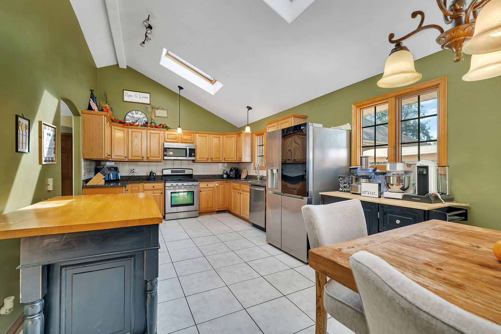 9417 West Steger Road Frankfort, IL 60423 - Photo 9 of 52 a kitchen with stainless steel appliances kitchen island granite countertop a refrigerator a stove a sink dishwasher and white cabinets with wooden floor