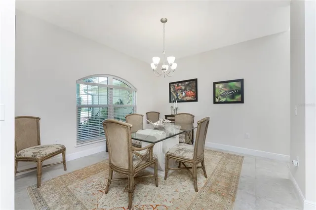 a dining room with furniture a chandelier and window