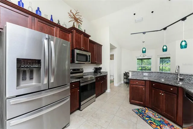 a kitchen with stainless steel appliances granite countertop a refrigerator and a stove