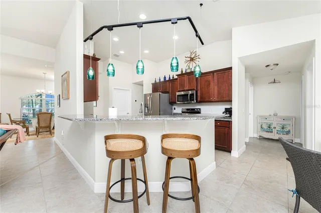 a kitchen with stainless steel appliances granite countertop a stove a sink and a refrigerator