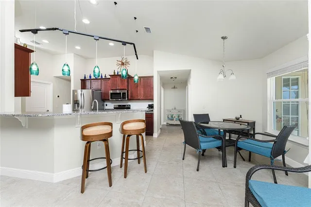 a kitchen with stainless steel appliances kitchen island granite countertop a table and chairs in it