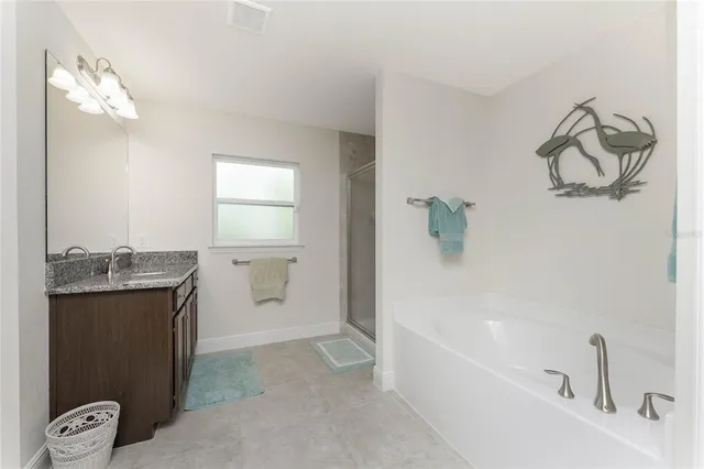 a bathroom with a granite countertop sink a toilet and bathtub