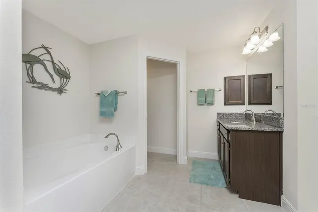 a bathroom with a tub sink and mirror