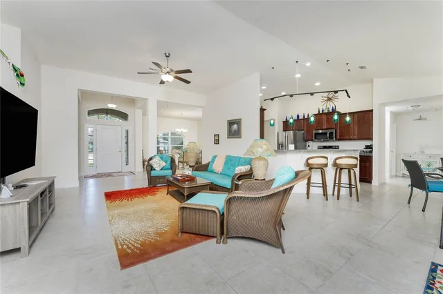 a living room with furniture kitchen view and a flat screen tv