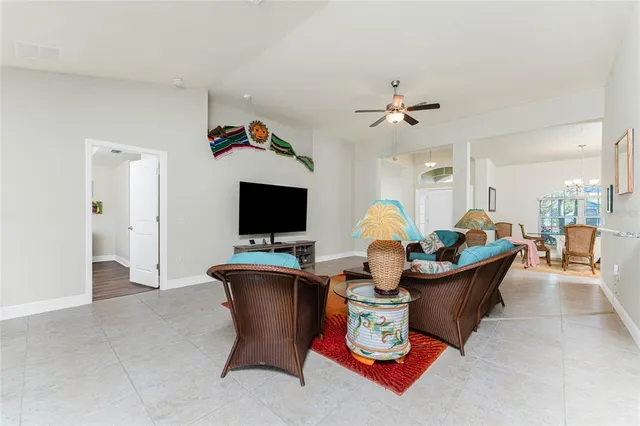a living room with furniture a flat screen tv and kitchen view