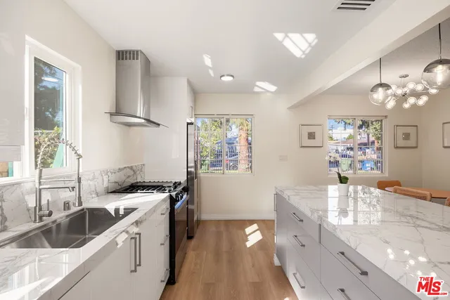 a kitchen with granite countertop a sink stove and cabinets