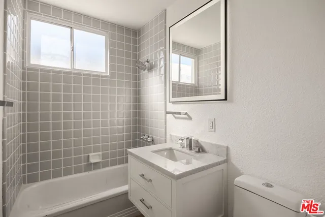 a bathroom with a sink toilet vanity and tub