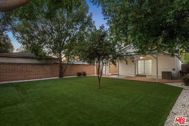 a backyard of a house with table and chairs