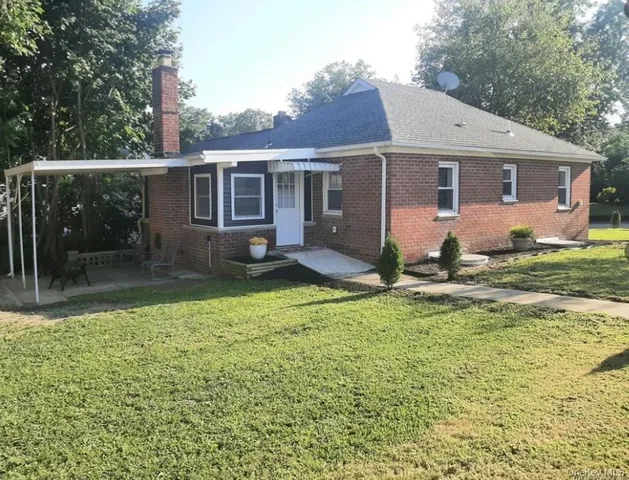 a view of a yard in front of a house with large tree