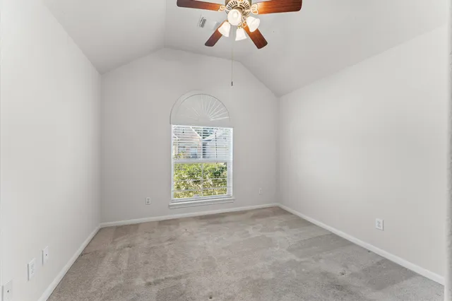 an empty room with a chandelier fan