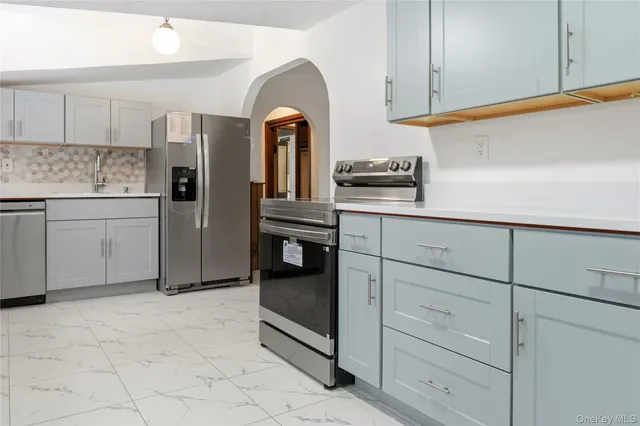 a kitchen with white cabinets and appliances
