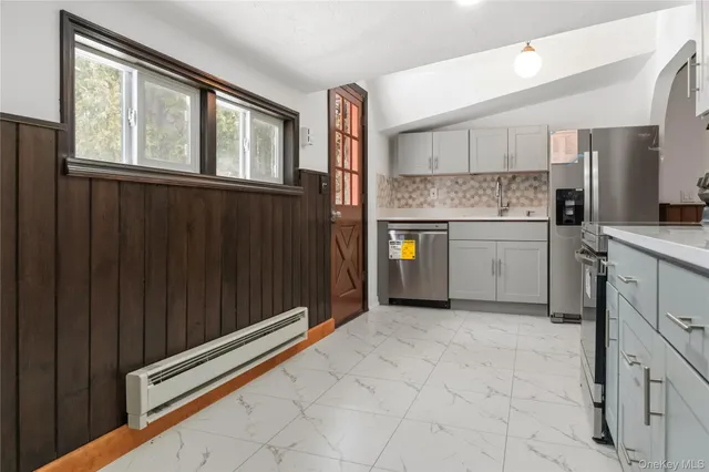 a kitchen with a refrigerator and white cabinets