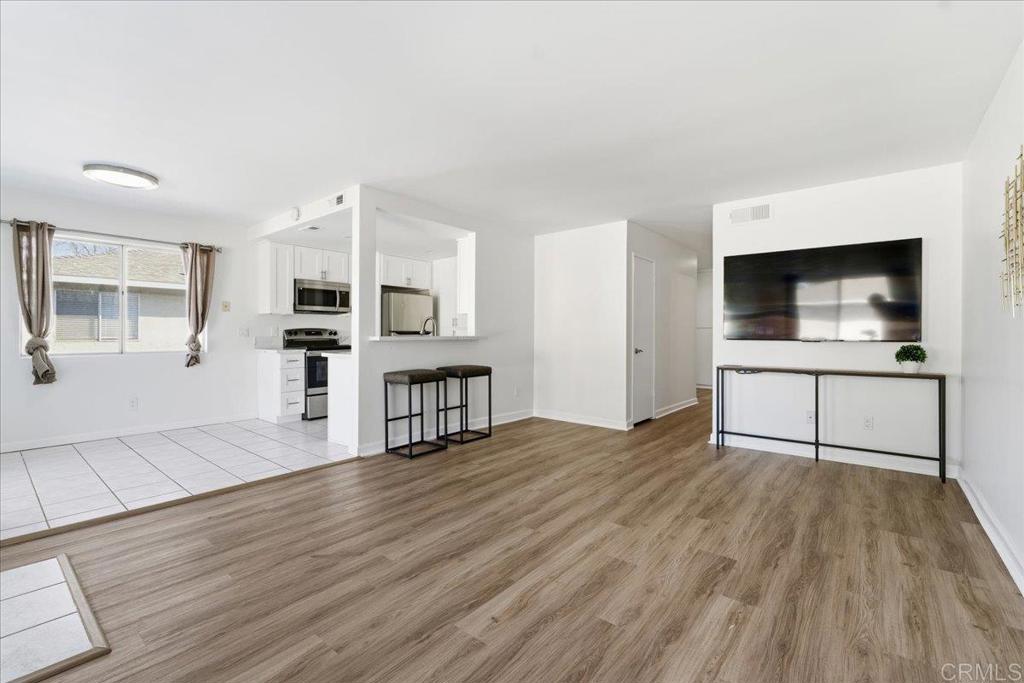 a view of a kitchen with wooden floor and electronic appliances