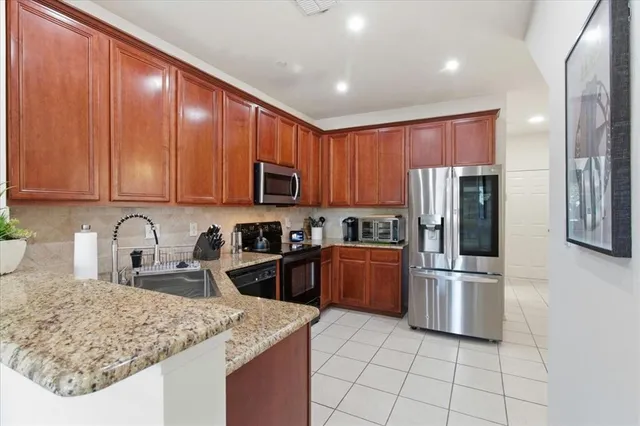 a kitchen with stainless steel appliances granite countertop a refrigerator sink and stove