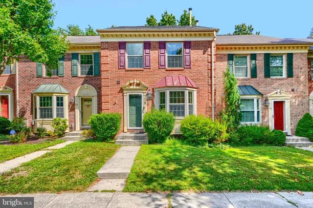 front view of a brick house with a yard