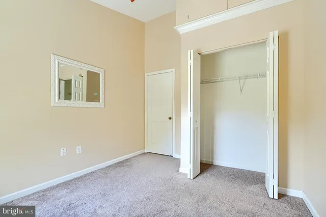a view of an empty room with closet and a window