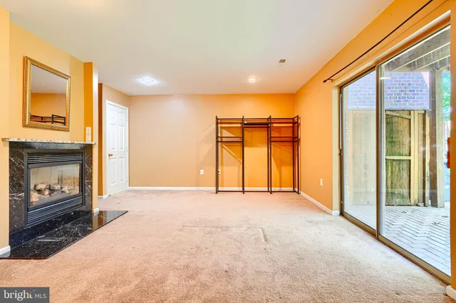 a view of an empty room with a fireplace and a window
