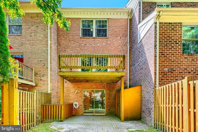 a view of a house with a small yard and wooden fence
