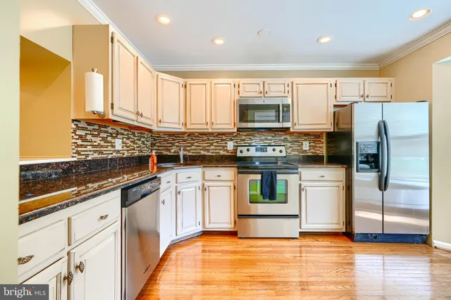 a kitchen with stainless steel appliances a stove a sink and a refrigerator