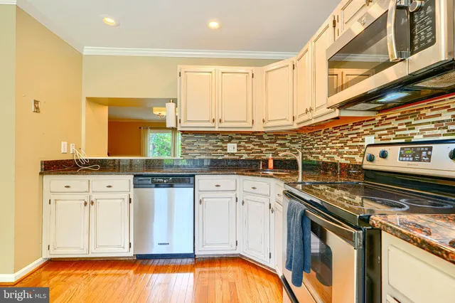 a kitchen with stainless steel appliances granite countertop a stove and a microwave