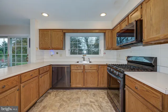 a kitchen with stainless steel appliances granite countertop a stove sink and cabinets