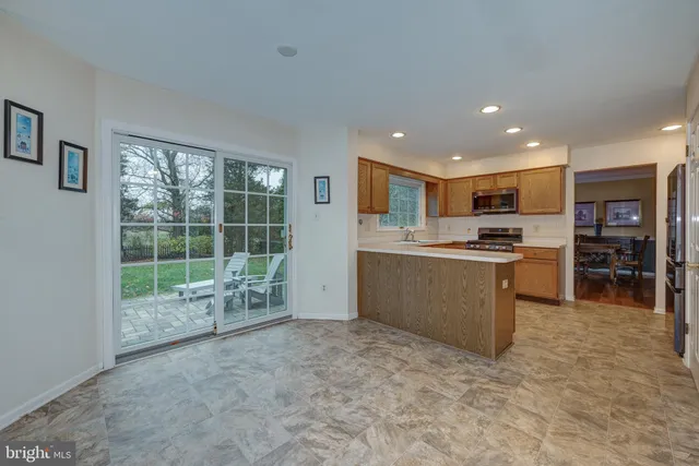 a open kitchen with kitchen island a large window and a refrigerator