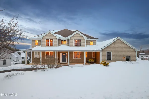 a view of a house with a yard covered in snow