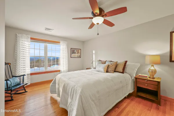 a view of a hallway with wooden floor and windows
