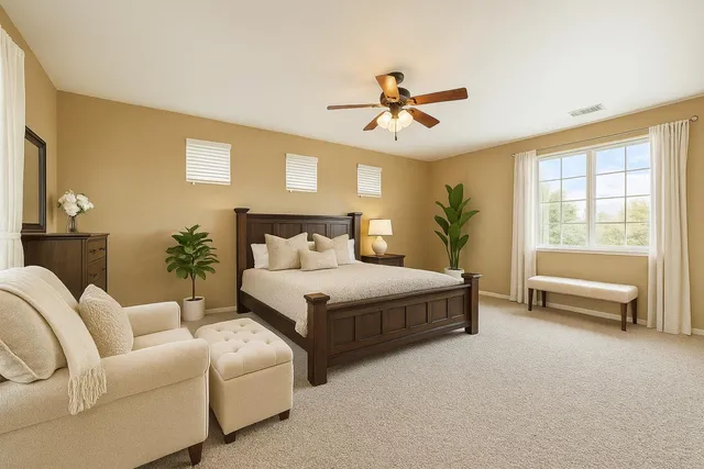 a bedroom with a large bed couch and a window