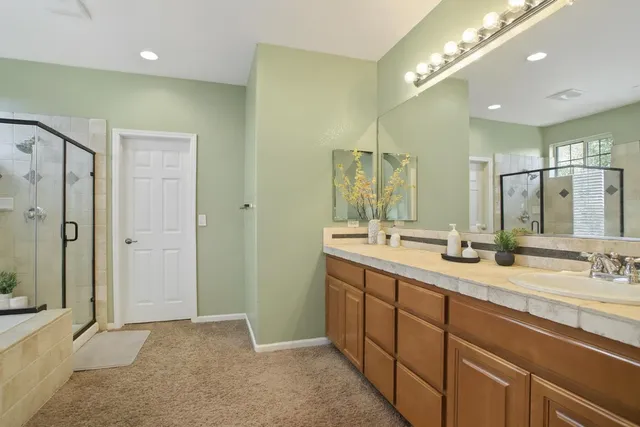 a bathroom with a double vanity sink mirror and shower