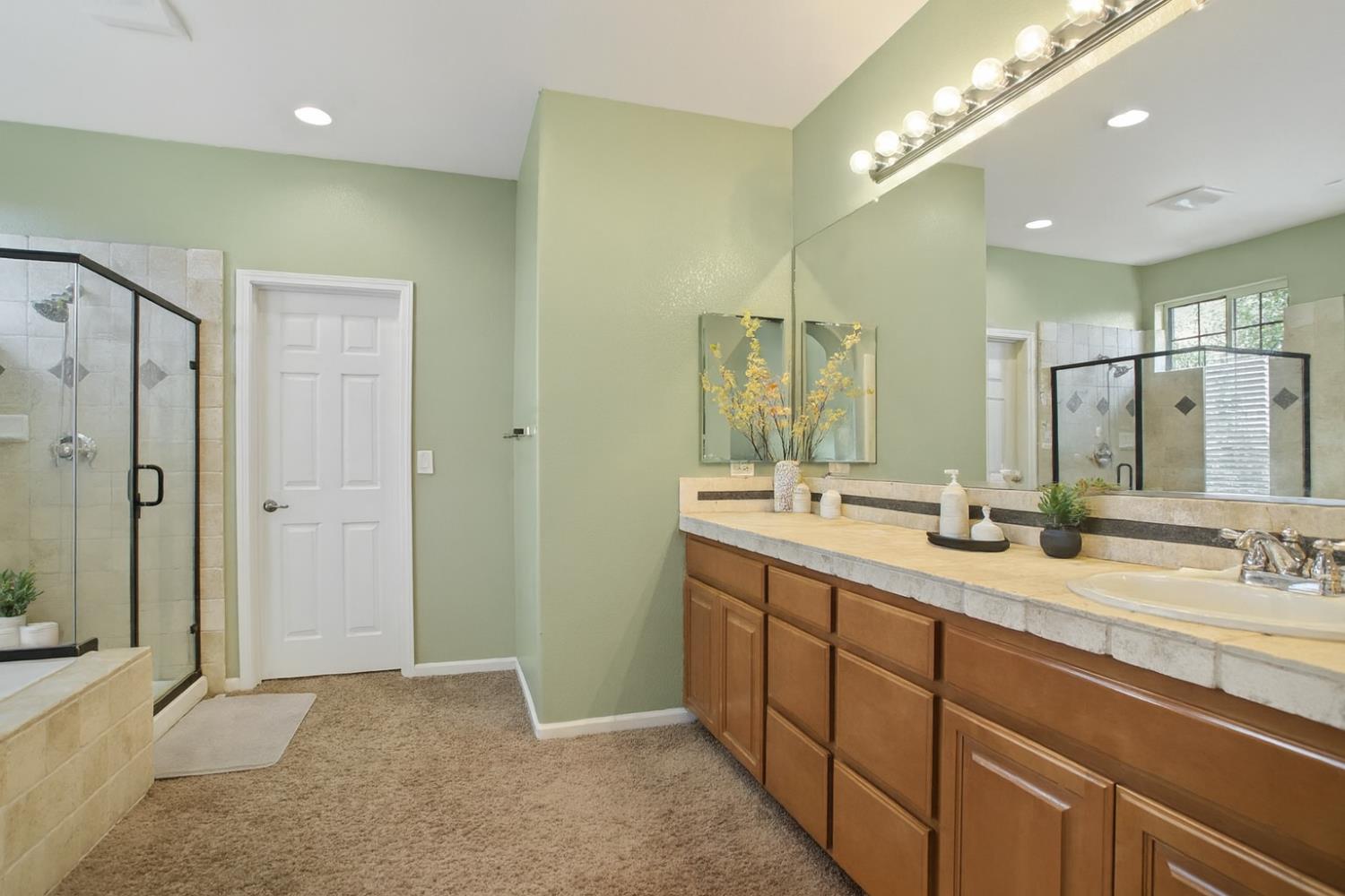 10148 Tony Court Stockton, CA 95209 - Photo 9 of 12 a bathroom with a double vanity sink mirror and shower