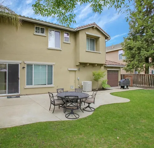 a view of an house with backyard space and patio