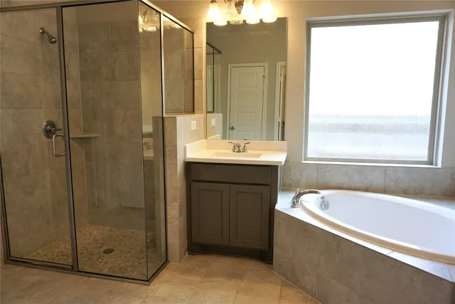 a bathroom with a tub sink and shower