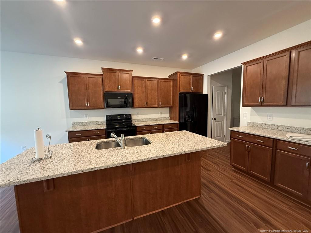 240 Planters Lane Coats, NC 27521 - Photo 4 of 18 a kitchen with kitchen island granite countertop a sink refrigerator and cabinets