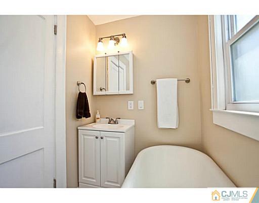 1982 Oak Tree Road Edison, NJ 08820 - Photo 8 of 25 a bathroom with a sink a toilet and mirror