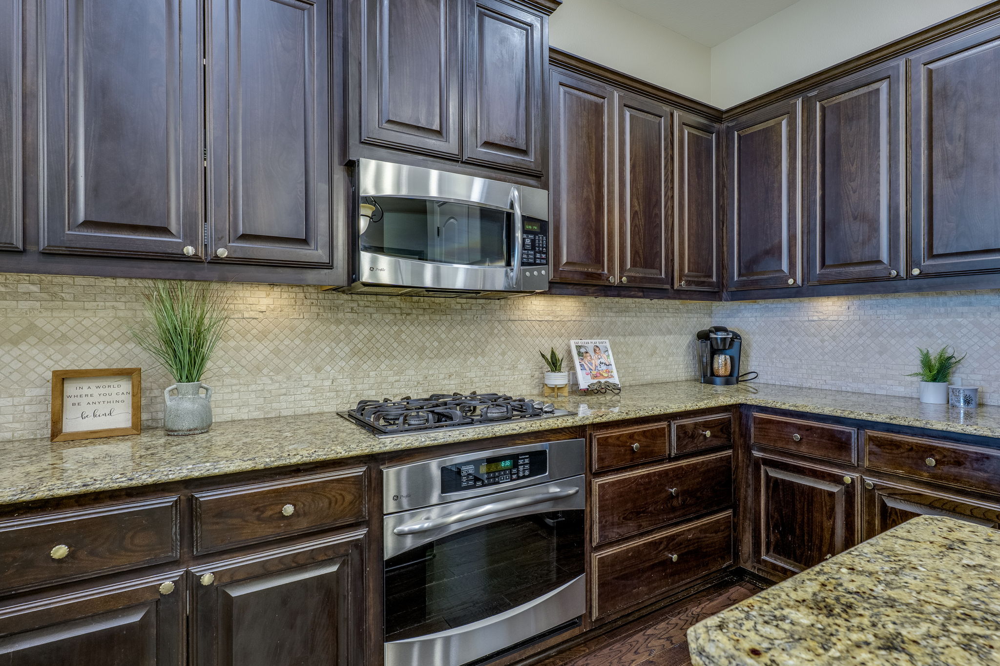 11601 Shadestone Terrace Austin, TX 78732 - Photo 18 of 40 a kitchen with stainless steel appliances granite countertop wooden cabinets and a stove top oven