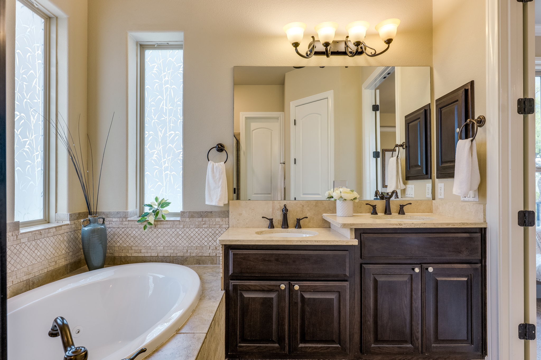 11601 Shadestone Terrace Austin, TX 78732 - Photo 32 of 40 a bathroom with a tub double vanity sink and mirror