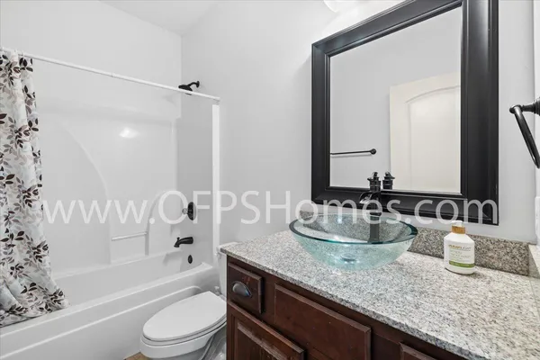 a bathroom with a granite countertop sink mirror toilet and bathtub