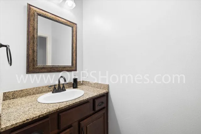a bathroom with a granite countertop sink and a mirror
