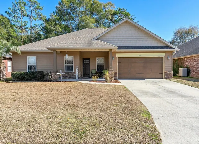 a front view of a house with a yard and potted plants